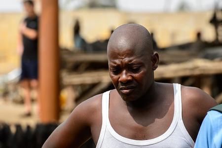 LOME, TOGO - Jan 9, 2017: Unidentified Togolese man in white shirt looks down at the Lome fetish market. Togo people suffer of poverty due to the bad economyのeditorial素材