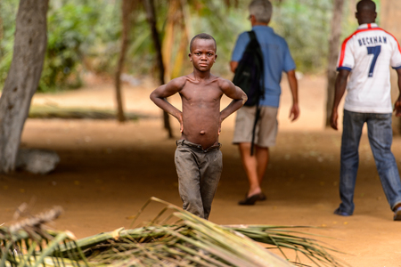 LOME, TOGO - Jan 9, 2017: Unidentified Togolese young topless boy puts his hands on his hips. Togo children suffer of poverty due to the bad economyのeditorial素材