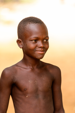 LOME, TOGO - Jan 9, 2017: Unidentified Togolese topless young boy with dejected smile. Togo children suffer of poverty due to the bad economyのeditorial素材