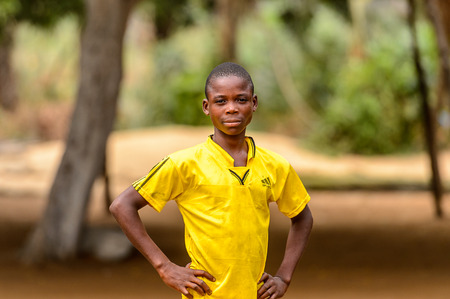 LOME, TOGO - Jan 9, 2017: Unidentified Togolese young boy in yellow suit puts his hands on his hips. Togo  children suffer of poverty due to the bad economyのeditorial素材
