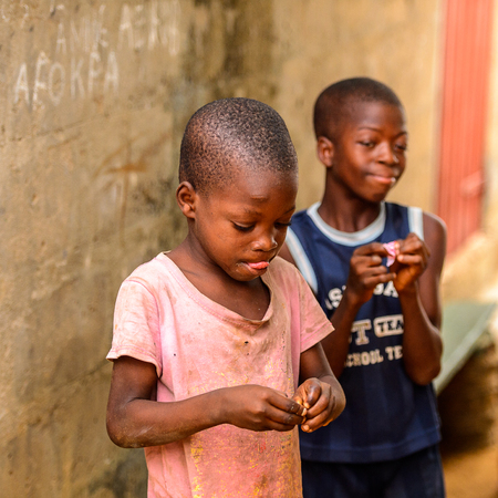 LOME, TOGO - Jan 9, 2017: Unidentified Togolese young boy in dirty clothes shows his tongue. Togo...