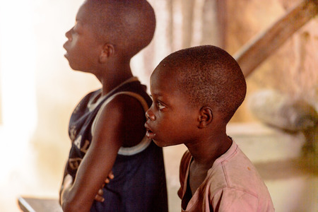 LOME, TOGO - Jan 9, 2017: Unidentified Togolese attentive young boys in the local shaman's house. Togo children suffer of poverty due to the bad economyのeditorial素材