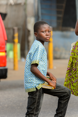 ACCRA, GHANA - Jan 8, 2017: Unidentified Ghanaian boy holds a book in his hands. People of Ghana suffer of poverty due to the economic situationのeditorial素材