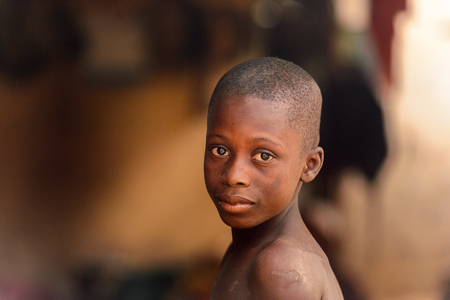 LOME, TOGO - Jan 9, 2017: Unidentified Togolese young boy in the local shaman's house. Togo people suffer of poverty due to the bad economyのeditorial素材