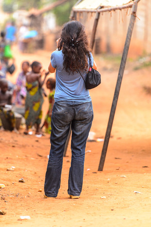 OUIDAH, BENIN - Jan 9, 2017: Unidentified European curly woman from behind. Benin people suffer of poverty due to the bad economyのeditorial素材