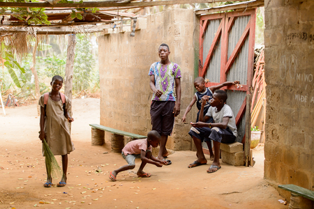 LOME, TOGO - Jan 9, 2017: Unidentified Togolese young boys near the entrance to the local shaman's house. Togo people suffer of poverty due to the bad economyのeditorial素材