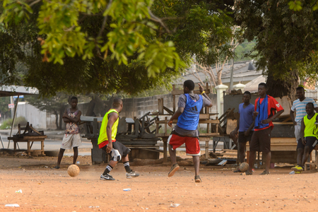 ACCRA, GHANA - Jan 8, 2017: Unidentified Ghanaian boys play football on the street. People of Ghana suffer of poverty due to the economic situationのeditorial素材