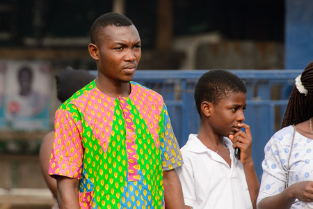 ACCRA, GHANA - Jan 8, 2017: Unidentified Ghanaian group of people stand on the street. People of Ghana suffer of poverty due to the economic situationのeditorial素材
