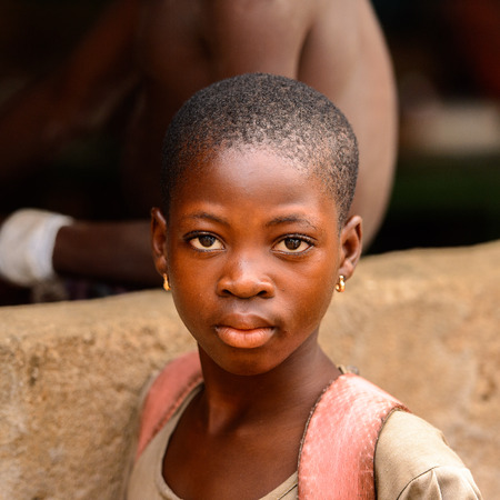 LOME, TOGO - Jan 9, 2017: Unidentified Togolese young girl in earings and with backpack behind. Togo people suffer of poverty due to the bad economyのeditorial素材