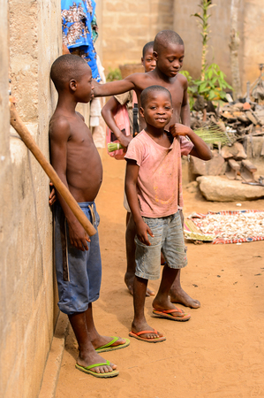 LOME, TOGO - Jan 9, 2017: Unidentified Togolese young boy leans on the wall of the local shaman's house. Togo children suffer of poverty due to the bad economyのeditorial素材