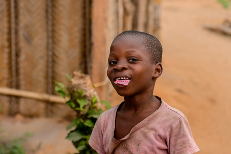 LOME, TOGO - Jan 9, 2017: Unidentified Togolese young boy puts candyinto his mouth. Togo children suffer of poverty due to the bad economyのeditorial素材