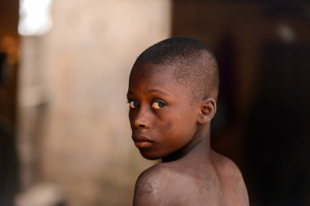 LOME, TOGO - Jan 9, 2017: Unidentified Togolese young boy in the local shaman's house. Togo children suffer of poverty due to the bad economyのeditorial素材