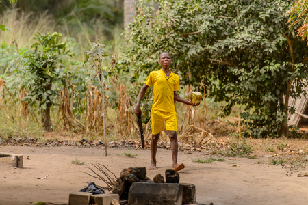 LOME, TOGO - Jan 9, 2017: Unidentified Togolese young boy walks near local shaman's house. Togo people suffer of poverty due to the bad economyのeditorial素材