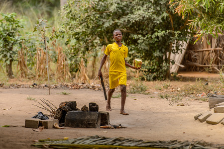 LOME, TOGO - Jan 9, 2017: Unidentified Togolese young boy walks near local shaman's house. Togo people suffer of poverty due to the bad economyのeditorial素材