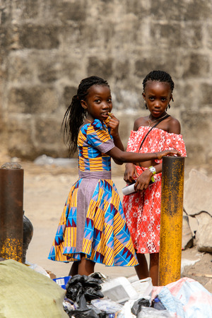 ACCRA, GHANA - Jan 8, 2017: Unidentified Ghanaian girls with braids in colored dresses  on the street. People of Ghana suffer of poverty due to the economic situationのeditorial素材