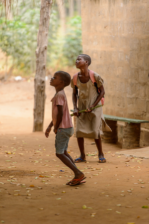 LOME, TOGO - Jan 9, 2017: Unidentified Togolese young girl in a dress holds some kind of greenery. Togo people suffer of poverty due to the bad economyのeditorial素材