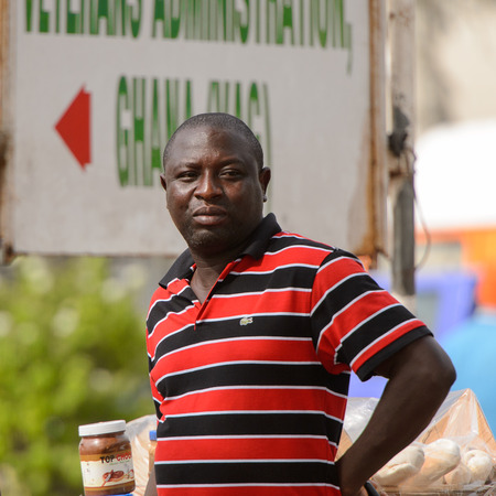 ACCRA, GHANA - Jan 8, 2017: Unidentified Ghanaian man in striped shirt on the street. People of Ghana suffer of poverty due to the economic situationのeditorial素材