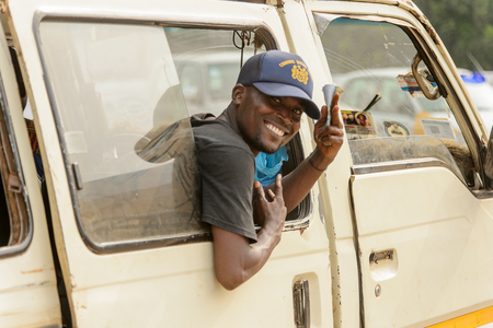 ACCRA, GHANA - Jan 8, 2017: Unidentified Ghanaian man looks out of the car with a smile on his face. People of Ghana suffer of poverty due to the economic situationのeditorial素材