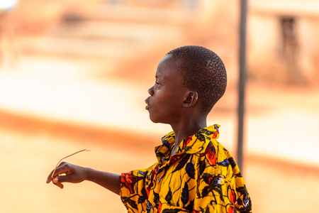 OUIDAH, BENIN - Jan 9, 2017: Unidentified Beninese boy in colored shirt raises his arm. Benin children suffer of poverty due to the bad economyのeditorial素材