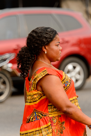 ACCRA, GHANA - Jan 8, 2017: Unidentified Ghanaian woman in colored dress with curly hair. People of Ghana suffer of poverty due to the economic situationのeditorial素材