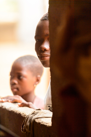 LOME, TOGO - Jan 9, 2017: Unidentified Togolese young boy and girl near the local shaman's house. Togo people suffer of poverty due to the bad economyのeditorial素材