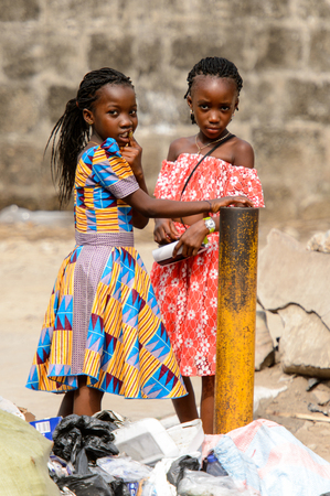 ACCRA, GHANA - Jan 8, 2017: Unidentified Ghanaian girls with braids in colored dresses  on the street. People of Ghana suffer of poverty due to the economic situationのeditorial素材