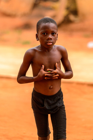 OUIDAH, BENIN - Jan 9, 2017: Unidentified Beninese  boy puts his hands on his chest. Benin children suffer of poverty due to the bad economyのeditorial素材