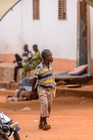 OUIDAH, BENIN - Jan 9, 2017: Unidentified Beninese boy walks in the street. Benin children suffer of poverty due to the bad economyのeditorial素材