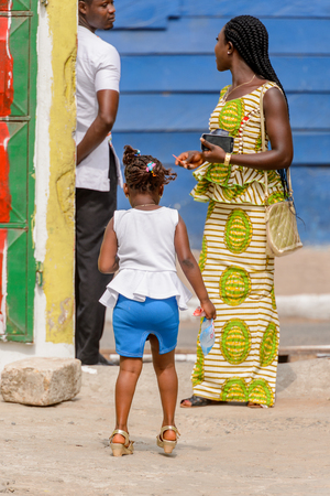 ACCRA, GHANA - Jan 8, 2017: Unidentified Ghanaian little girl from behind at the local market. People of Ghana suffer of poverty due to the economic situationのeditorial素材