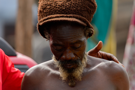 ACCRA, GHANA - Jan 8, 2017: Unidentified Ghanaian hippie man with beard stands at the local market. People of Ghana suffer of poverty due to the economic situationのeditorial素材