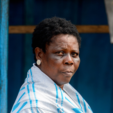 ACCRA, GHANA - Jan 8, 2017: Unidentified Ghanaian woman in white and blue clothes wears earings at the local market. People of Ghana suffer of poverty due to the economic situationのeditorial素材