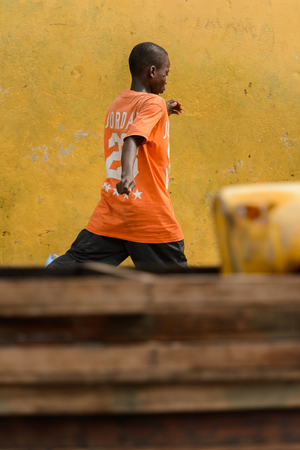 ACCRA, GHANA - Jan 8, 2017: Unidentified Ghanaian boy runs at the local market. People of Ghana suffer of poverty due to the economic situationのeditorial素材