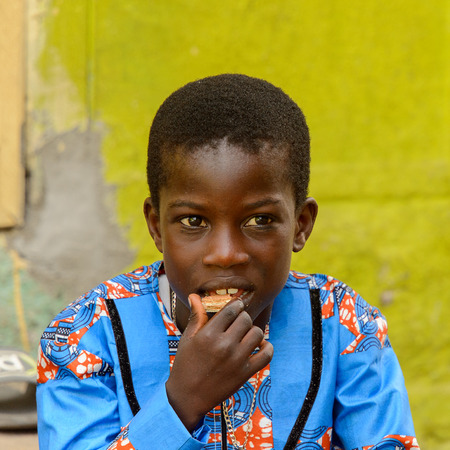 ACCRA, GHANA - Jan 8, 2017: Unidentified Ghanaian little boy eats at the local market. People of Ghana suffer of poverty due to the economic situationのeditorial素材