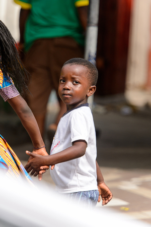 ACCRA, GHANA - Jan 8, 2017: Unidentified Ghanaian little boy holds his mother's hand on the street. Children of Ghana suffer of poverty due to the economic situationのeditorial素材