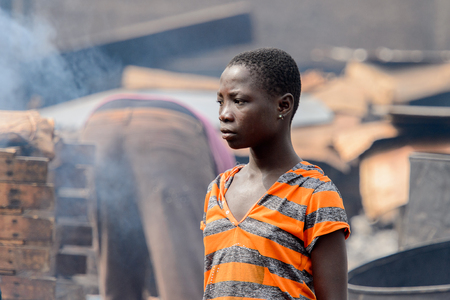 ACCRA, GHANA - Jan 8, 2017: Unidentified Ghanaian girl in striped shirt at the local market. People of Ghana suffer of poverty due to the economic situationのeditorial素材