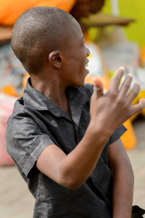 ACCRA, GHANA - Jan 8, 2017: Unidentified Ghanaian boys in black shirt smiles at the local market. People of Ghana suffer of poverty due to the economic situationのeditorial素材