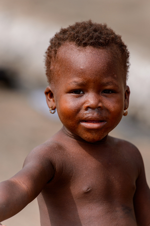 ACCRA, GHANA - Jan 8, 2017: Unidentified Ghanaian little girl in earings at the local market. People...