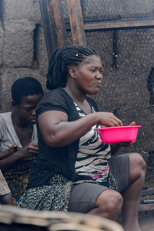 ACCRA, GHANA - Jan 8, 2017: Unidentified Ghanaian woman carries a bowl at the local market. People of Ghana suffer of poverty due to the economic situationのeditorial素材