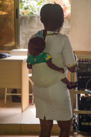 ACCRA, GHANA - Jan 8, 2017: Unidentified Ghanaian little girl is carried by her mother at the local market. People of Ghana suffer of poverty due to the economic situationのeditorial素材