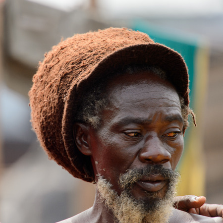 ACCRA, GHANA - Jan 8, 2017: Unidentified Ghanaian hippie man with beard stands at the local market. People of Ghana suffer of poverty due to the economic situationのeditorial素材