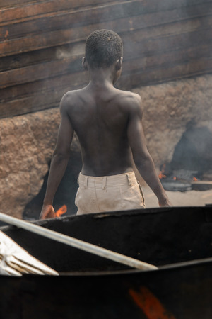 ACCRA, GHANA - Jan 8, 2017: Unidentified Ghanaian topless boy in beige shorts stands at the local market. People of Ghana suffer of poverty due to the economic situationのeditorial素材