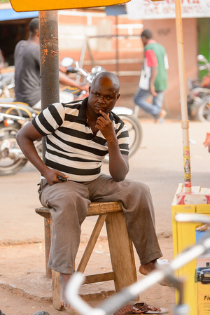 ACCRA, GHANA - Jan 8, 2017: Unidentified Ghanaian man sits on the street. People of Ghana suffer of poverty due to the economic situationのeditorial素材