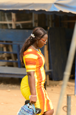 ACCRA, GHANA - Jan 8, 2017: Unidentified Ghanaian woman walks on the street. People of Ghana suffer of poverty due to the economic situationのeditorial素材