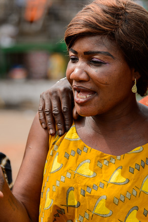 ACCRA, GHANA - Jan 8, 2017: Unidentified Ghanaian woman in mustard shirt with short haircut at the local market. People of Ghana suffer of poverty due to the economic situationのeditorial素材