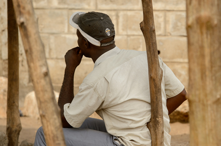 LOME, TOGO - Jan 9, 2017: Unidentified Togolese man in white shirt and a cap from behind. Togo...