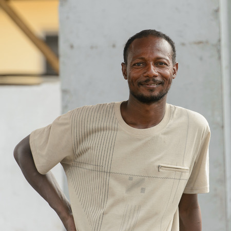 LOME, TOGO - Jan 9, 2017: Unidentified Togolese man in white shirt with beard smiles. Togo people suffer of poverty due to the bad economyのeditorial素材