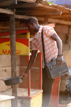 ACCRA, GHANA - Jan 8, 2017: Unidentified Ghanaian man holds a bowl on the street. People of Ghana suffer of poverty due to the economic situationのeditorial素材
