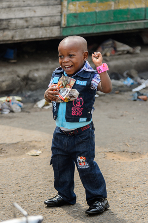 ACCRA, GHANA - Jan 8, 2017: Unidentified Ghanaian boys holds food in paper at the local market. People of Ghana suffer of poverty due to the economic situationのeditorial素材