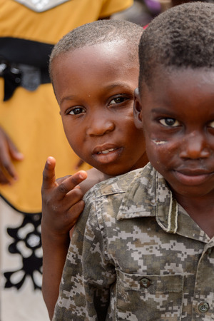 ACCRA, GHANA - Jan 8, 2017: Unidentified Ghanaian little boy in military shirt at the local market. People of Ghana suffer of poverty due to the economic situationのeditorial素材
