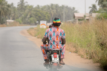 LOME, TOGO - Jan 9, 2017: Unidentified Togolese man rides a motorcycle. Togo people suffer of poverty due to the bad economyのeditorial素材
